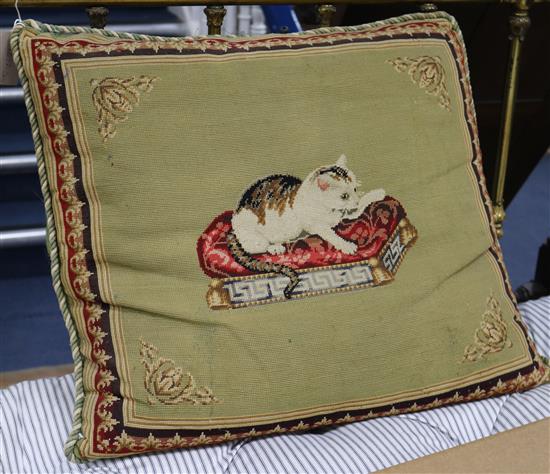 A rectangular cushion, the cover embroidered in petit point with a cat seated on a key pattern framed stool